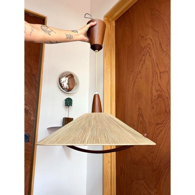 Striking mid-century pendant light by German-Swiss manufacturer Temde Leuchten, dating to the 1960s. The large conical...
