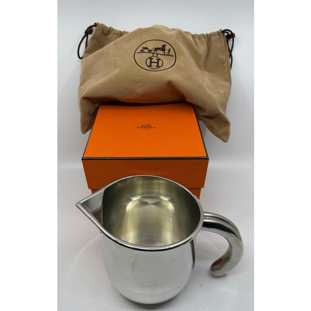 A lovely Hermes pitcher marked on the base Hermes Etain which we believes means Tin or Pewter. The pitcher has its...