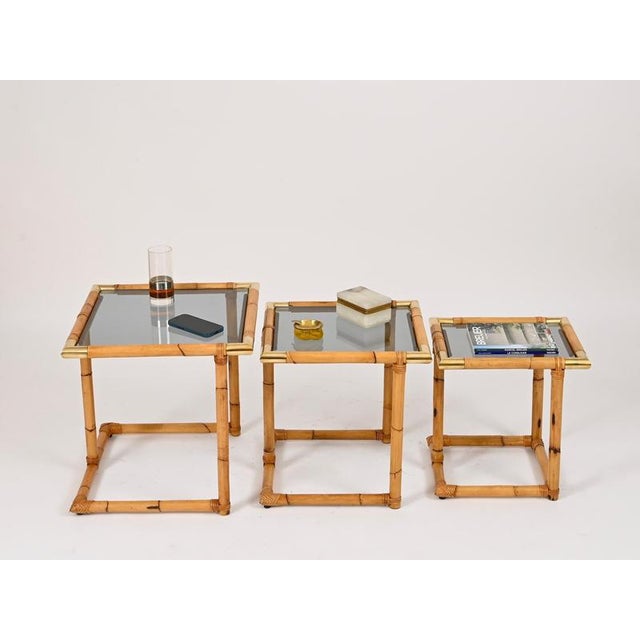 Stunning and unique set of three mid-century nesting tables entirely crafted in rattan, solid brass and hand-woven wicker...