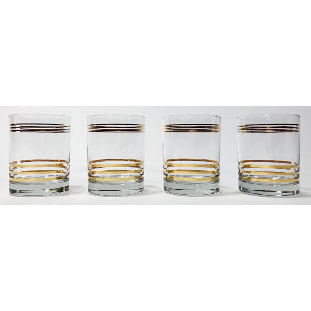 Rich looking set of four (4) vintage Mid Century Modern style lowball glasses. Small gold bands to top of glass with...