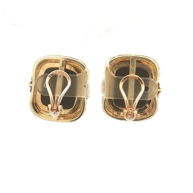 Elegant earrings featuring black onyx cabochons set in 14k gold. Accented with round white diamonds on each side. These...