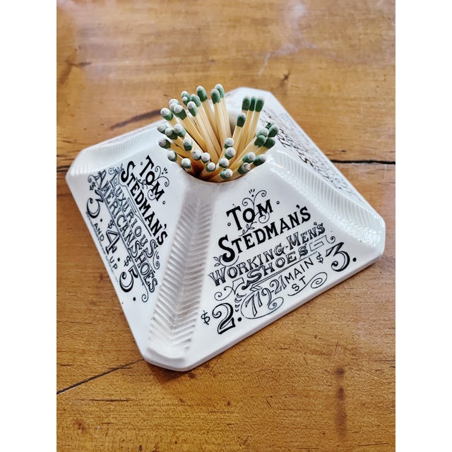 An antique English stoneware match striker, made to be used in a pub, bar or hotel lobby to advertise a shoe store that...