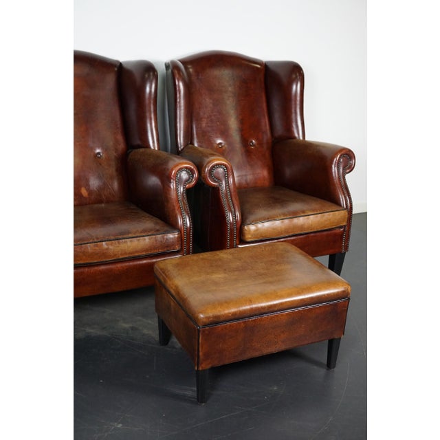 This pair of cognac/burgundy-colored leather club chairs come from the Netherlands. They are upholstered with hand...