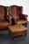 This pair of cognac/burgundy-colored leather club chairs come from the Netherlands. They are upholstered with hand...