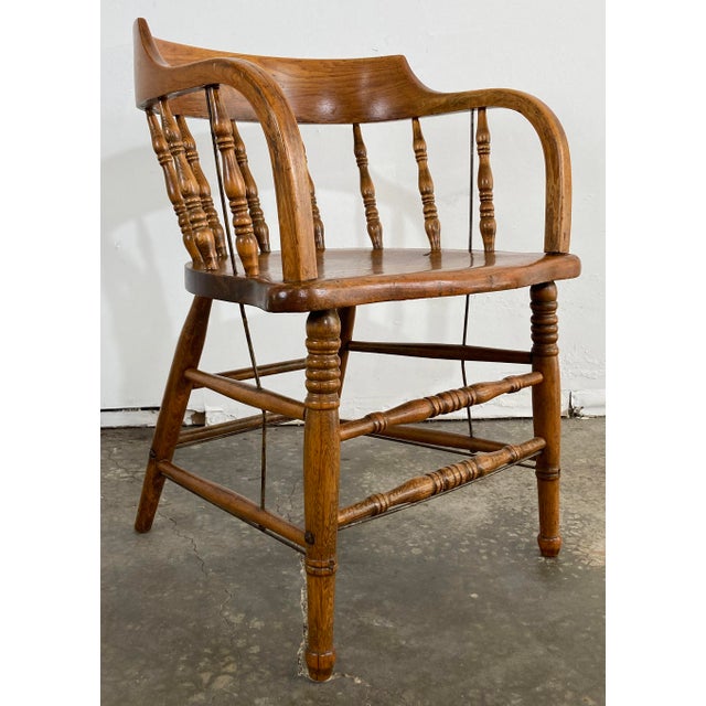 Antique rustic saloon style captain's chair with bentwood back and arms and turned wood spindles. Original finish has a...