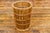 A Country style woven rattan waste basket with tapering lines. This vintage country-style woven rattan waste basket is a...