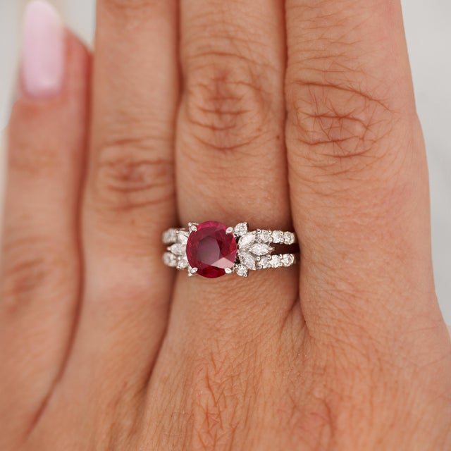 GIA-certified 2.00 carat natural ruby of Burma origin is set in PT900 platinum with a rounded oval profile and flanked by...