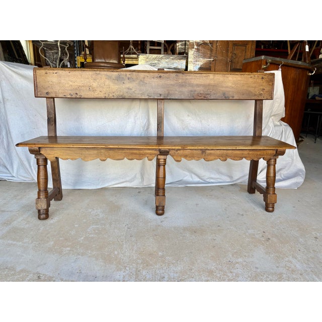 Found in Italy, this 19th Century Bench was crafted from walnut in the late 1800's. The bench features a handcarved back...