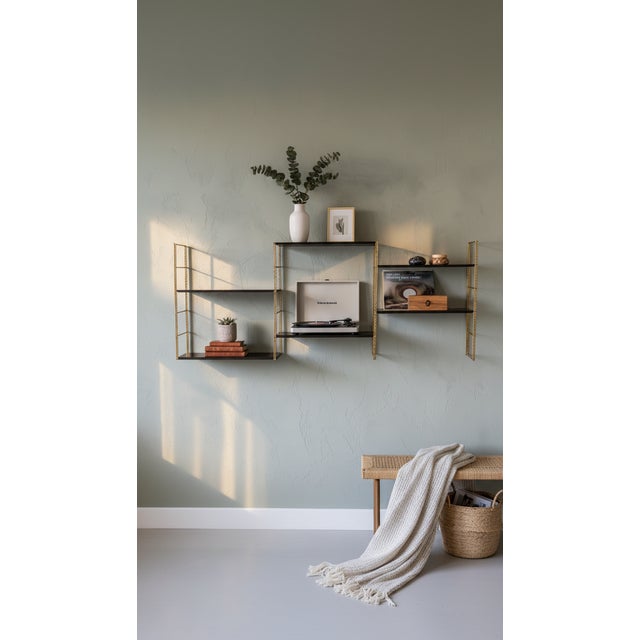 Wall shelf comprising four gold-plated twisted steel uprights and six black lacquered metal shelves. Upright height: 58 cm...
