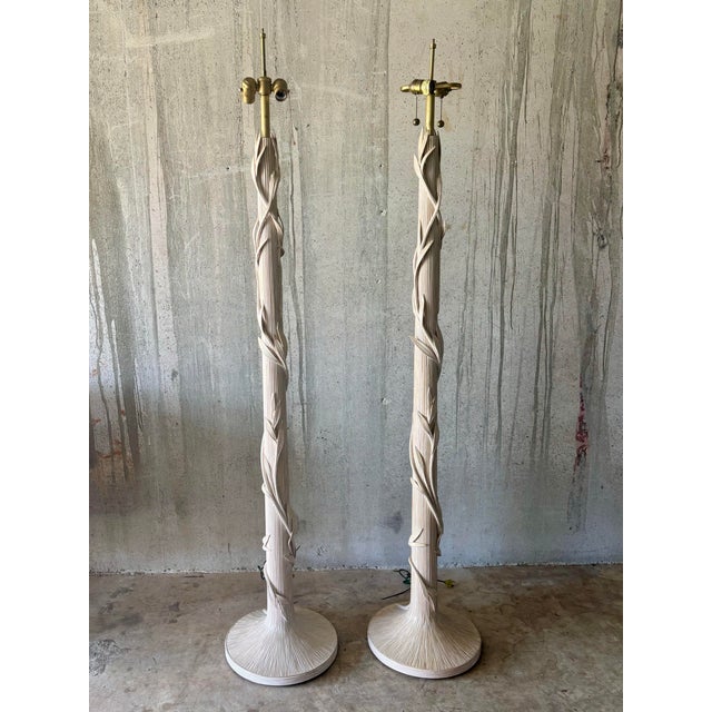 A sculptural pair of vintage coastal floor lamps crafted from pencil reed, featuring dimensional leaf accents climbing the...