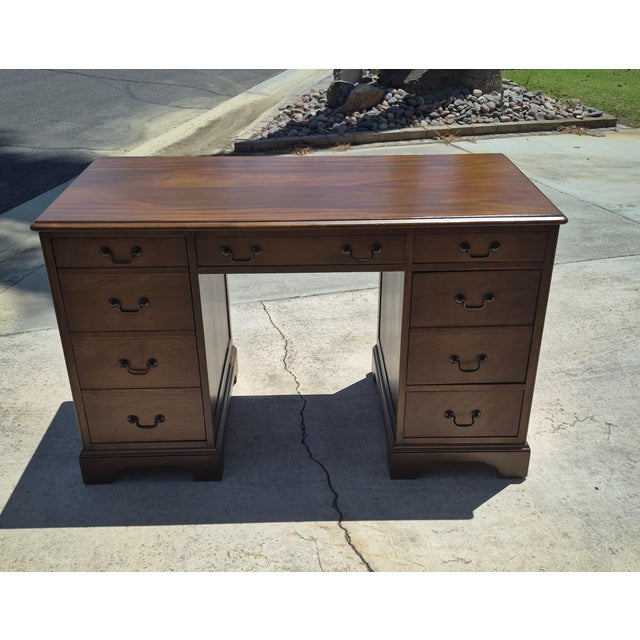 This Sligh-Lowry double-pedestal kneehole desk was crafted by the renowned Sligh Furniture Co. in Holland, Michigan,...