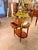 An elegant French Louis XVIstyle rolling serving table / étagère trolley, combining warm mahogany tones, delicate floral...