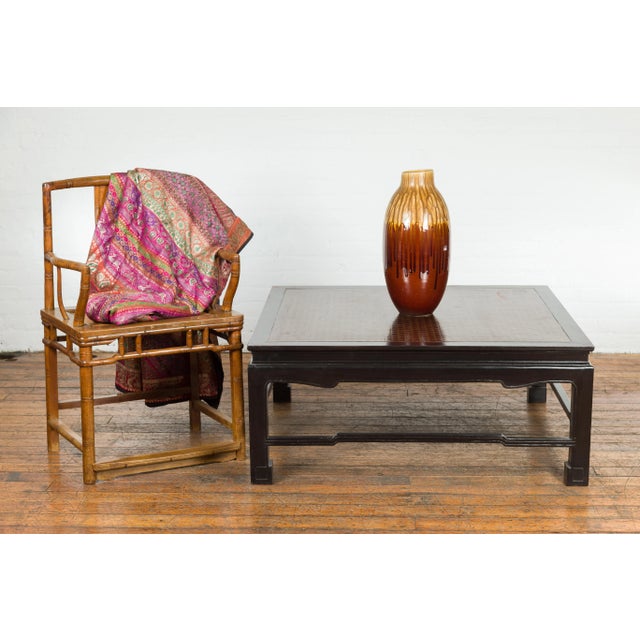 A vintage black lacquered coffee table from the mid 20th century with Negora lacquered top. This vintage mid-20th century...