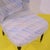 Light patterned fabric armchair with wooden legs and tips.