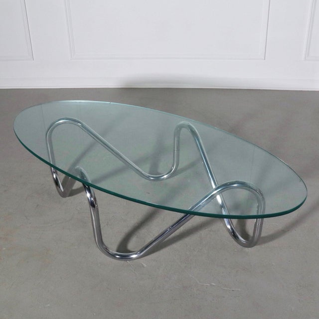 Sculptural tubular chrome free form coffee table with oval glass top. Wonderful vintage condition with glass top showing...