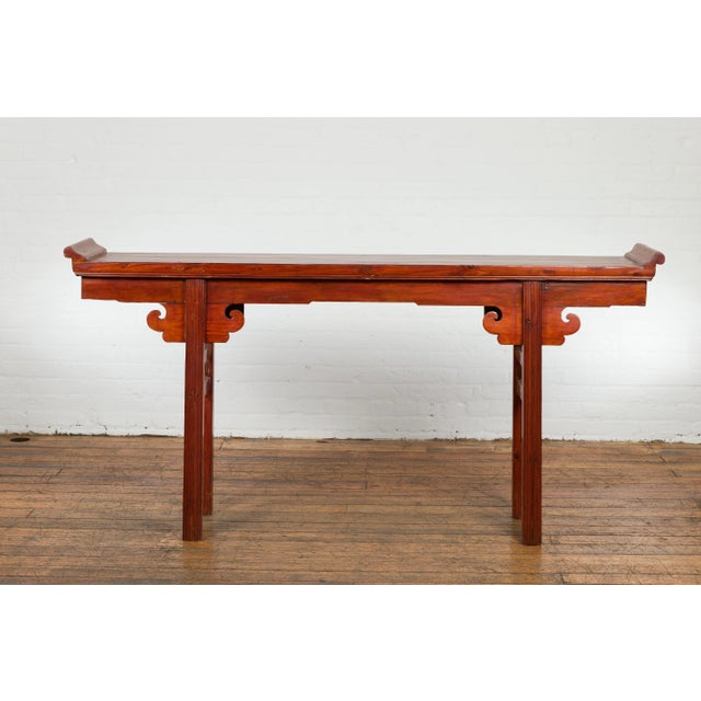 A Chinese Qing Dynasty period altar console table from the 19th century, with everted flanges, carved cloud motifs and...