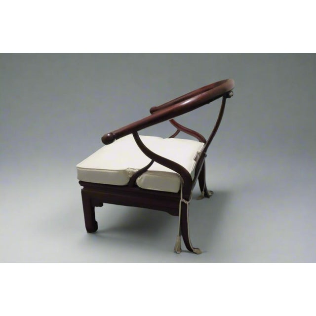 Gorgeous Ming style dark wood chair with wonderful scrolled arms and an intricate back design. The seat of the chair is...