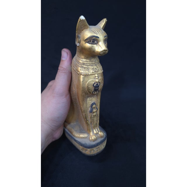 This striking sculpture represents the sacred cat goddess Bastet, one of the most beloved deities of ancient Egypt. Bastet...