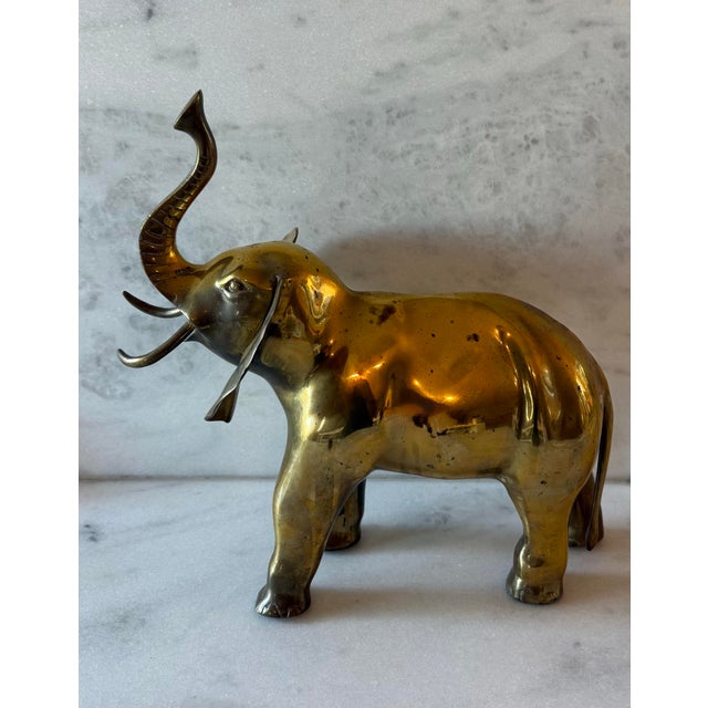 Large vintage mid century solid brass decorative elephant piece. The elephant is standing with his large ears out and his...