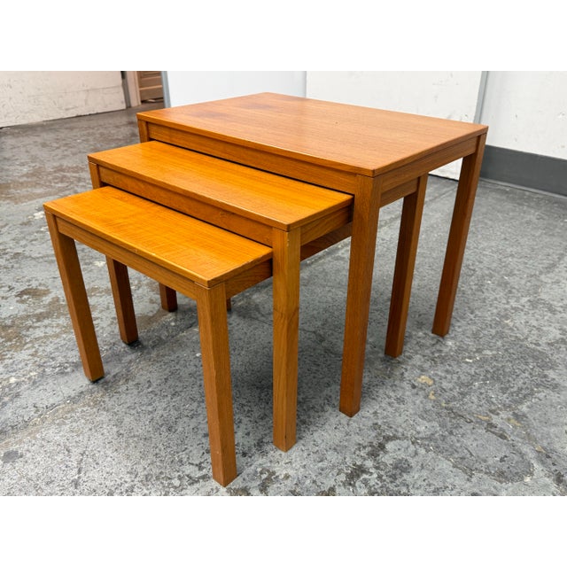 Design Plus Gallery presents a Set of Three Mid 20th Century Danish Modern Teak Nesting Tables from Bent Silberg Mobler....