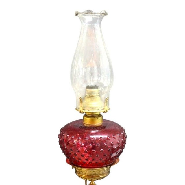 Antique electrified three-light hanging chandelier, circa 1880, with a brass frame and cranberry glass lamp reservoirs....