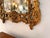 A magnificent Italian Baroque style wall mirror, exquisitely hand-carved in solid wood and finished in a rich antiqued gilt.