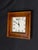 A handsome square wall clock by Sterling & Noble Clock Company, featuring a warm wood frame, classic ivory dial, bold...