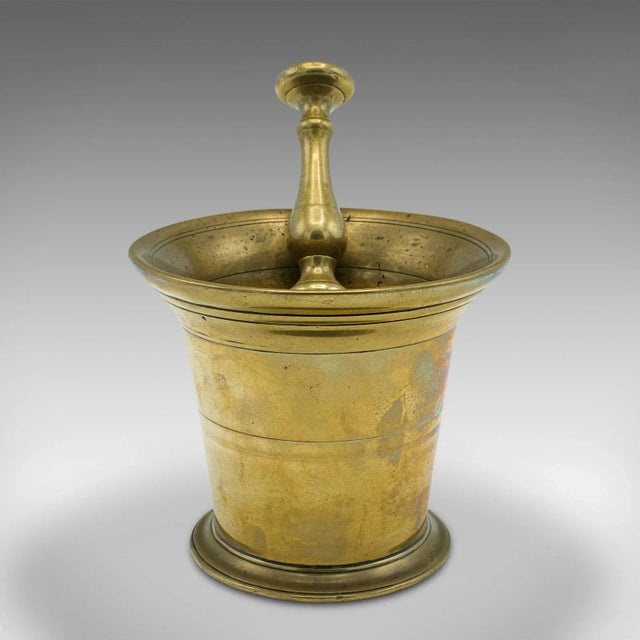 This is an antique apothecary mortar and pestle. An English, brass chemist's shop aid, dating to the early Victorian...