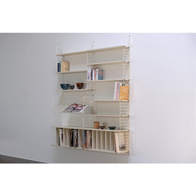 Rare variant of the modular STRING shelving system consisting of dark white painted shelves and white coated wall...