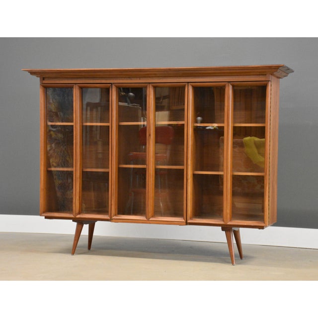 A mid century modern walnut bookcase with three glass doors. Made in the USA. Circa 1960’s. Original finish in excellent...