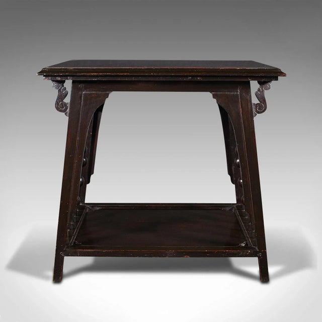 This is an antique occasional table. An English, ebonised side or lamp table in the manner of E.W. Godwin and the...