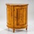 Biedermeier demi-lune cabinet veneered in birchwood, featuring two paneled doors and a simple profiled top. The interior...