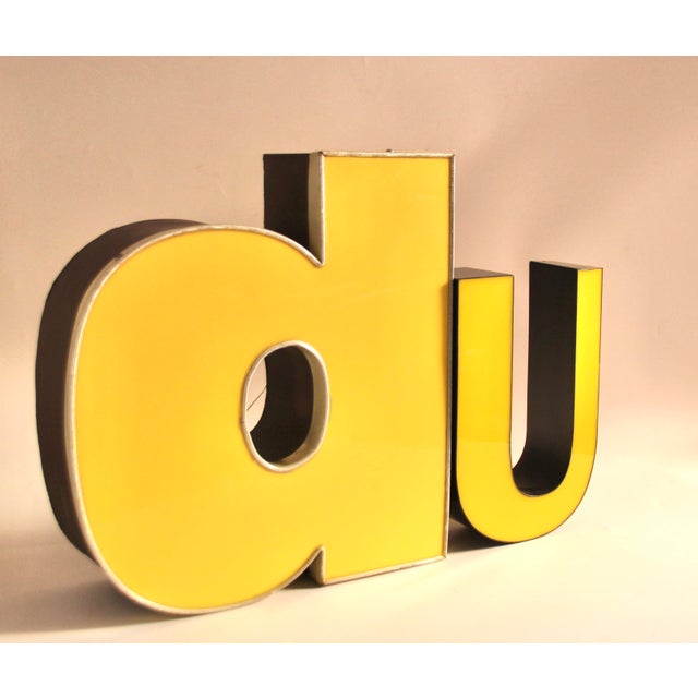 Vintage decorative neon letters made of yellow and white acrylic glass and metal. Fluorescent tubes replaced with energy-...