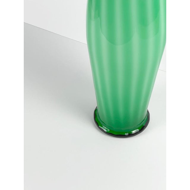 A tall green Empoli glass vase crafted by Vetreria Artistica Toscana in Empoli, Italy, around the 1970s. This mid-century...