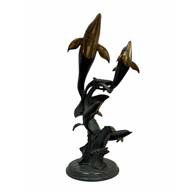 Bring the fluid energy of the ocean into your space with this magnificent vintage brass dolphin family sculpture by San...