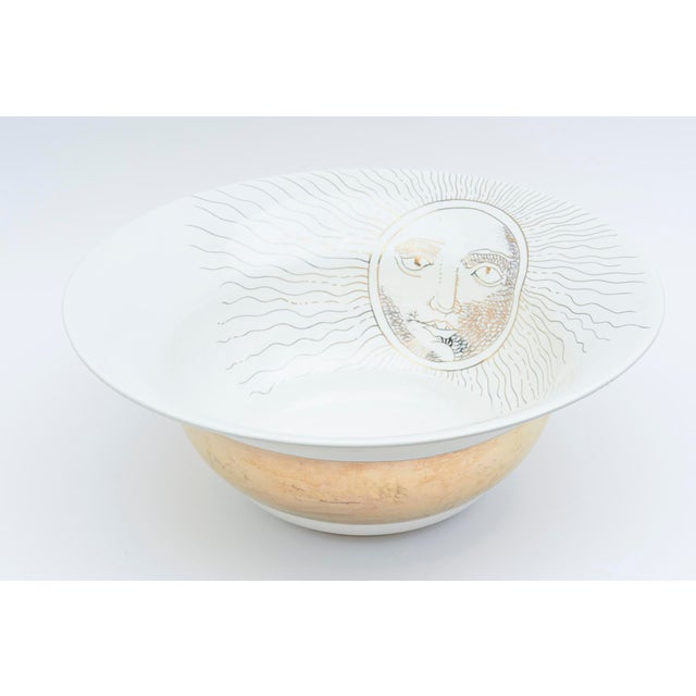 This wonderful very large signed artisan ceramic bowl is very Fornasetti style with a big sun face motif and gold band....