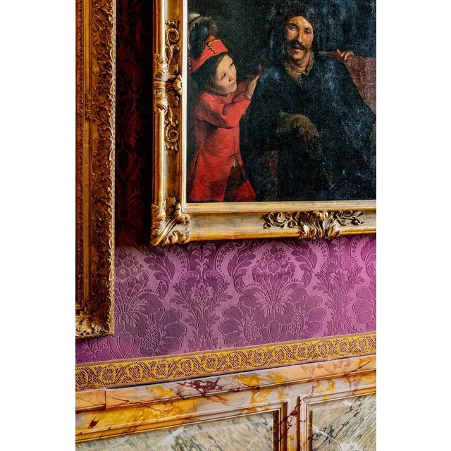 A young boy in red comforts a man dressed in black, his expression caught somewhere between surprise and concern. This...