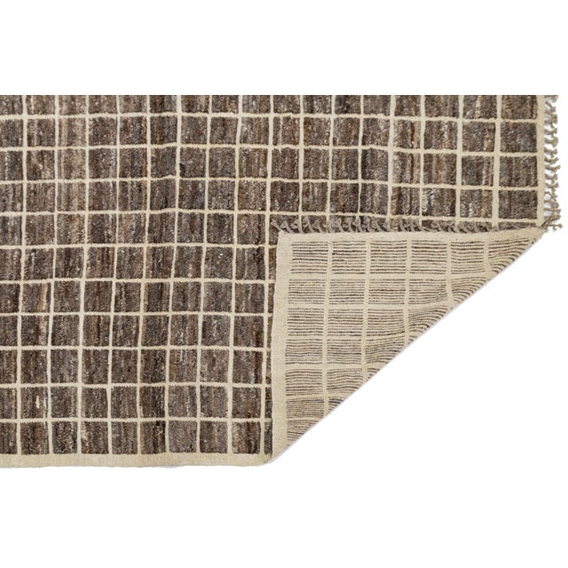 This modern rug takes inspiration from traditional Moroccan Beni Ourain motifs, featuring a clean, architectural grid...