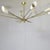 A ten-light chandelier with aluminium shades and a brass frame; its style and shape are reminiscent of the famous 1960s...