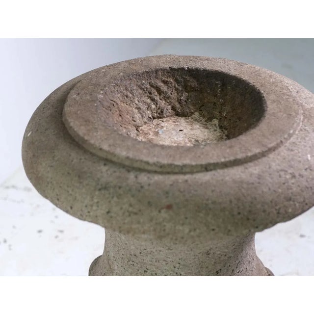 Carved granite gray architectural urn with a shallow top. The interior is shallow with concrete at the bottom. There is no...
