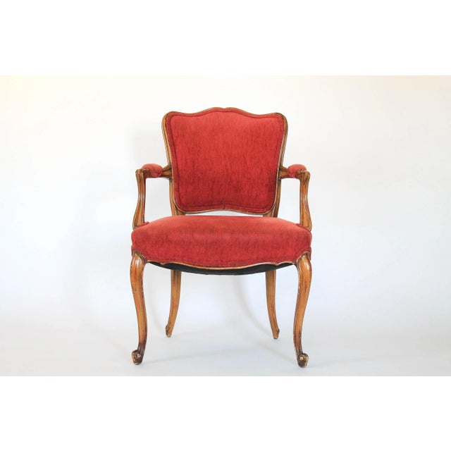 French upholstered Louis XV style fauteuil with salmon colored fabric and cabriole legs. No makers mark. Age wear to wood...