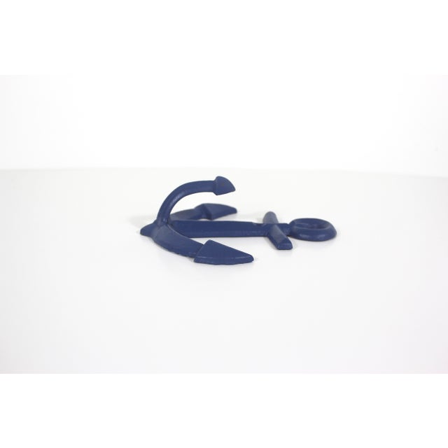 Vintage cast iron wall hook in the shape of an anchor. Painted blue. Has some nice patina. Two holes for screws. 5” wide...