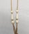 This is part of Chairish’s Costume Jewelry assortment. Early 1970s goldtone and resin faux-carved ivory sautoir necklace...