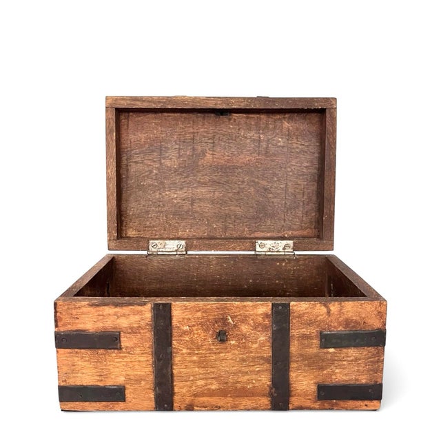 A handsomely aged wood box with iron straps, side banding, clasp, and two side handles.