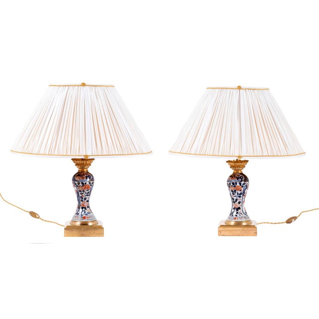 Pair of baluster shaped lamps in Imari porcelain. Chiselled and gilt bronze mount, standing on a moulded square shape...