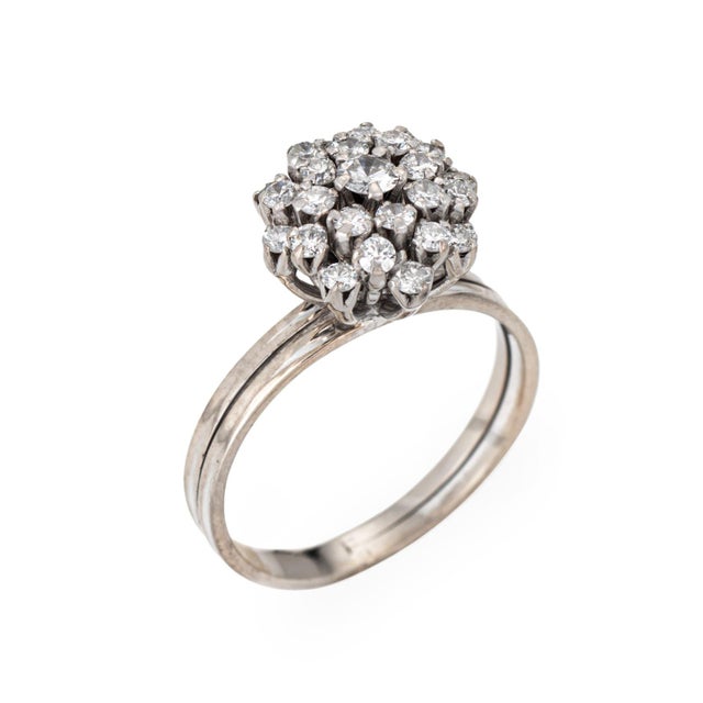 Stylish vintage diamond cluster ring crafted in 14k white gold (circa 1950s). Round brilliant cut diamonds total an...