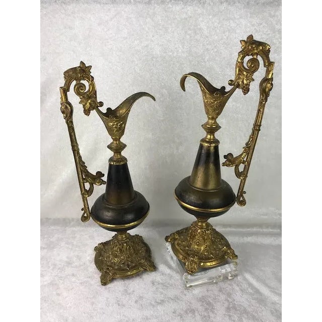Stunning pair of vintage ornate mantle pitchers / ewers in brass. Gilt style handle tapers to meet thicker base in brown,...