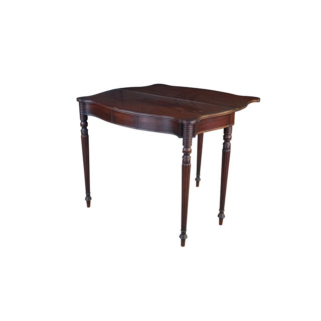 This antique early 19th-century mahogany game table demonstrates its versatile, functional design when fully opened,...