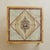 An onyx coffee table dating to the 1970s, its square brass frame enclosing an inlaid onyx top. At the center, four...
