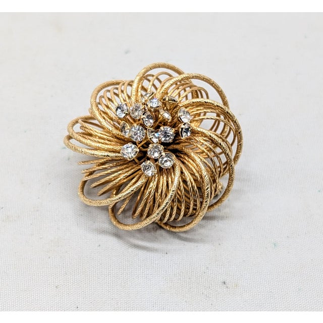 1960s circular goldtone wire wrapped in a spiral design with wires sticking out the center with prong set round clear...